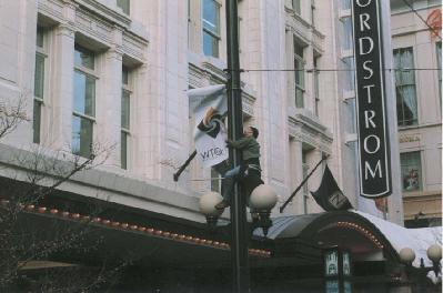 A demonstrator tears down a WTO banner.